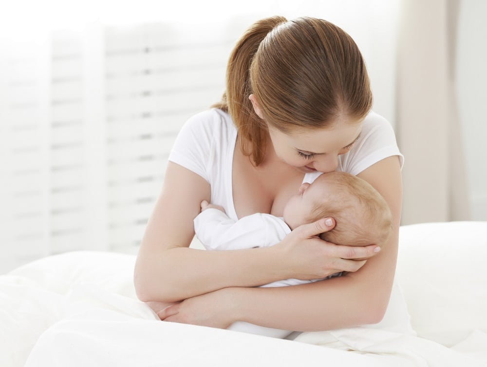 happy family newborn baby in embrace mother in white