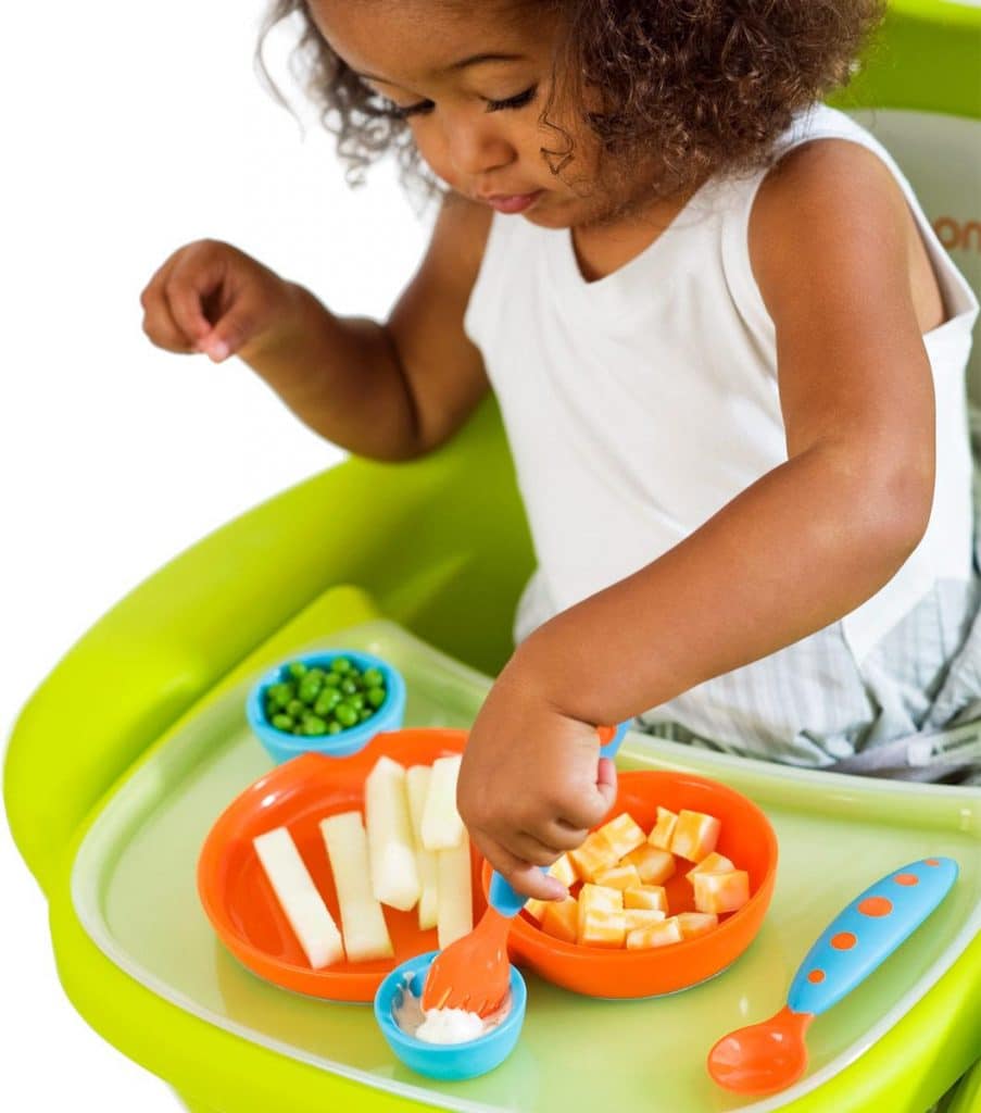 Baby eats with utensils