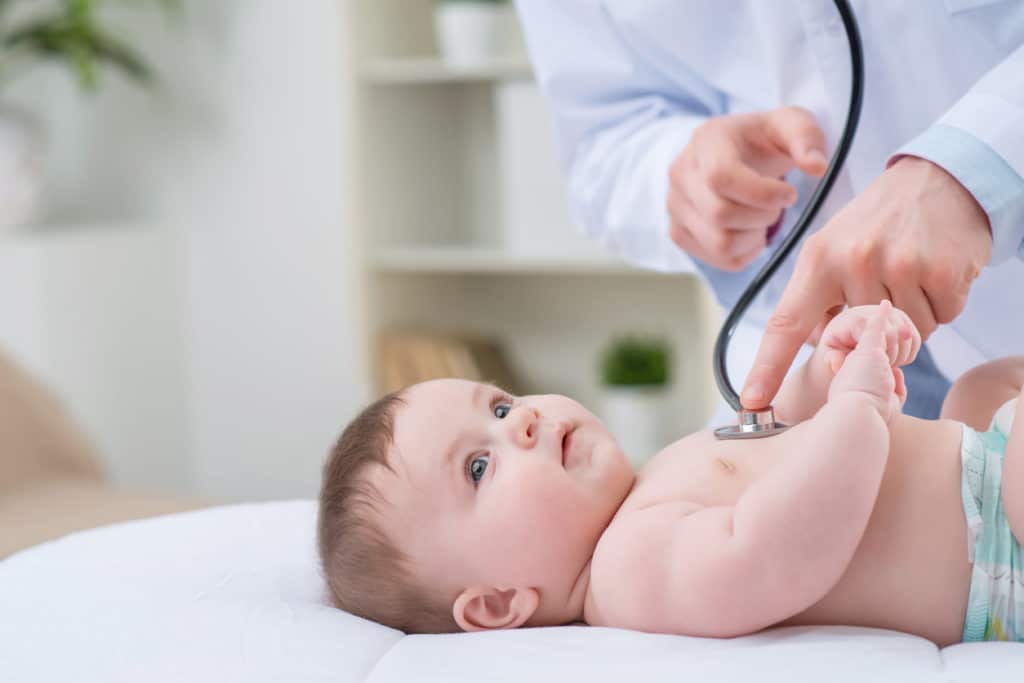 Professional pediatrician examining infant